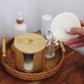 Bamboo storage box with stacked hemp cotton rounds; one round held in hand