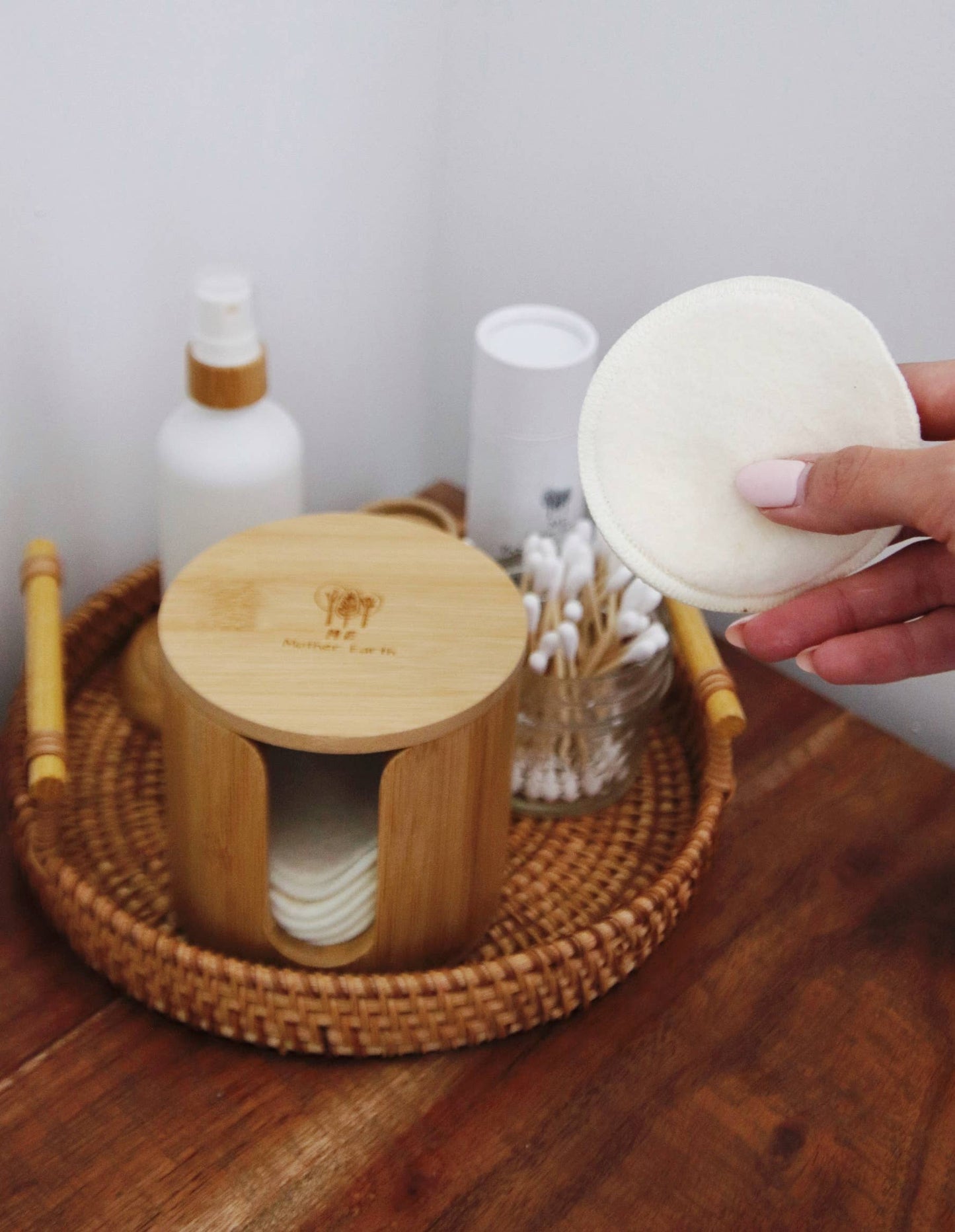 Bamboo storage box with stacked hemp cotton rounds; one round held in hand