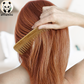 Wide-tooth bamboo comb brushing brown hair