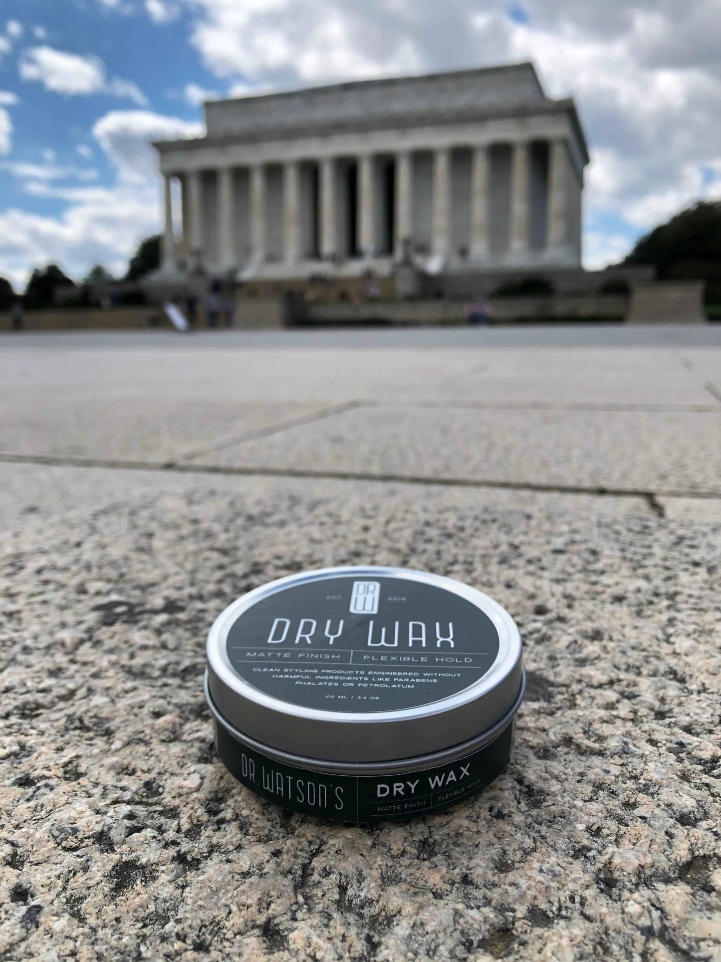 Hair dry wax tin with teal label on black container, matte finish