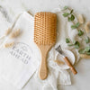 Bamboo hair brush with square paddle head, wooden handle, and rows of bristles