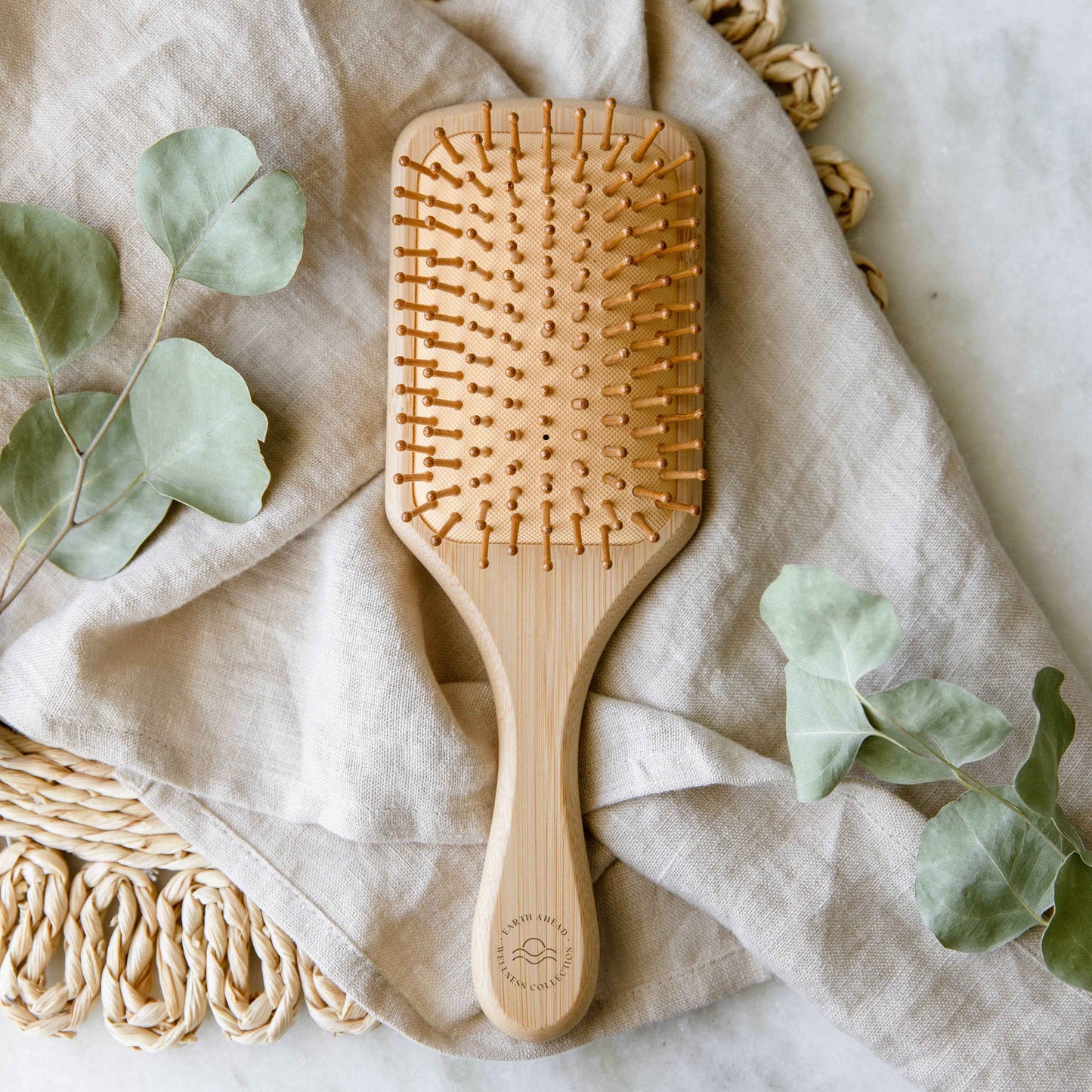 Bamboo hair brush paddle with rounded edges and wooden handle, dotted with pins