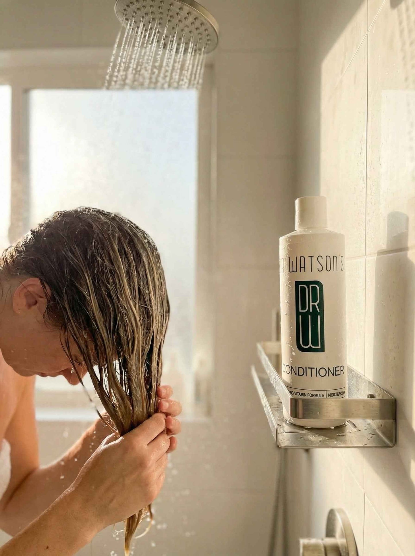Dr. Watson's conditioner bottle on bathroom shelf, white with pump cap and green label