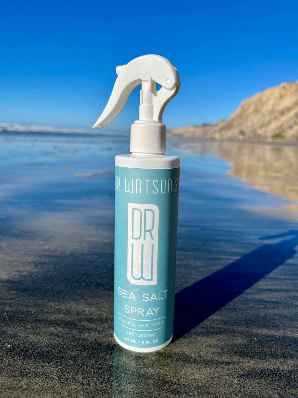 Sea salt spray bottle standing with white trigger sprayer, blue label details