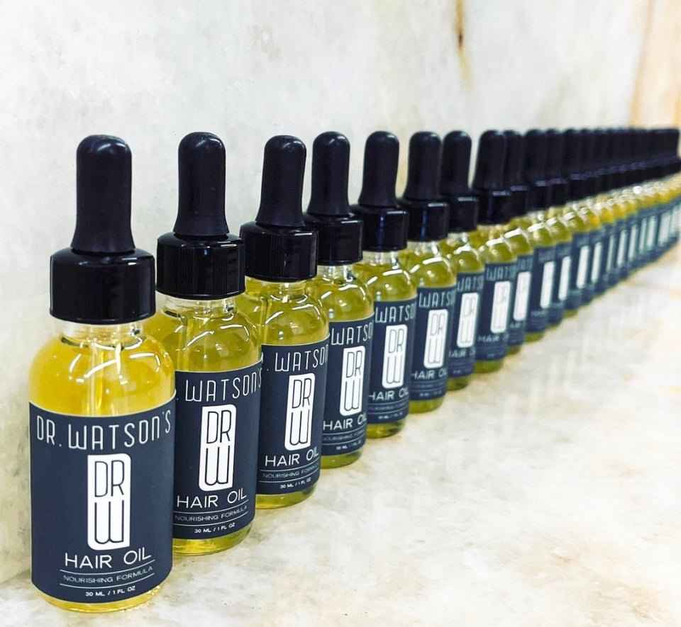 Row of hair oil bottles with black droppers, yellow oil, Dr Watsons labeling