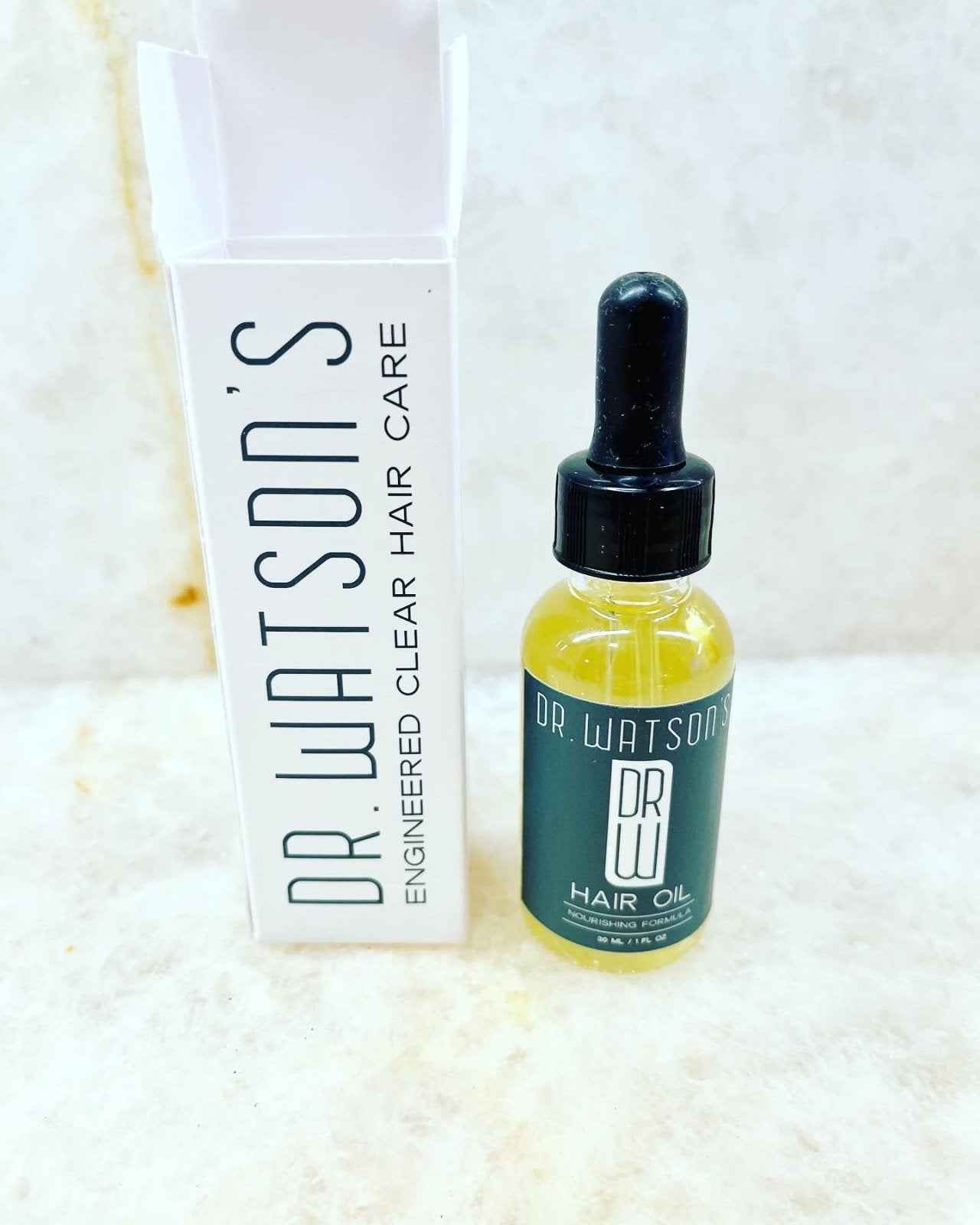 Hair oil bottle with dropper and white DR Watsons hair care box, yellow serum