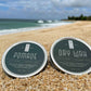 Two hair pomade tins with dark green tops and silver rims
