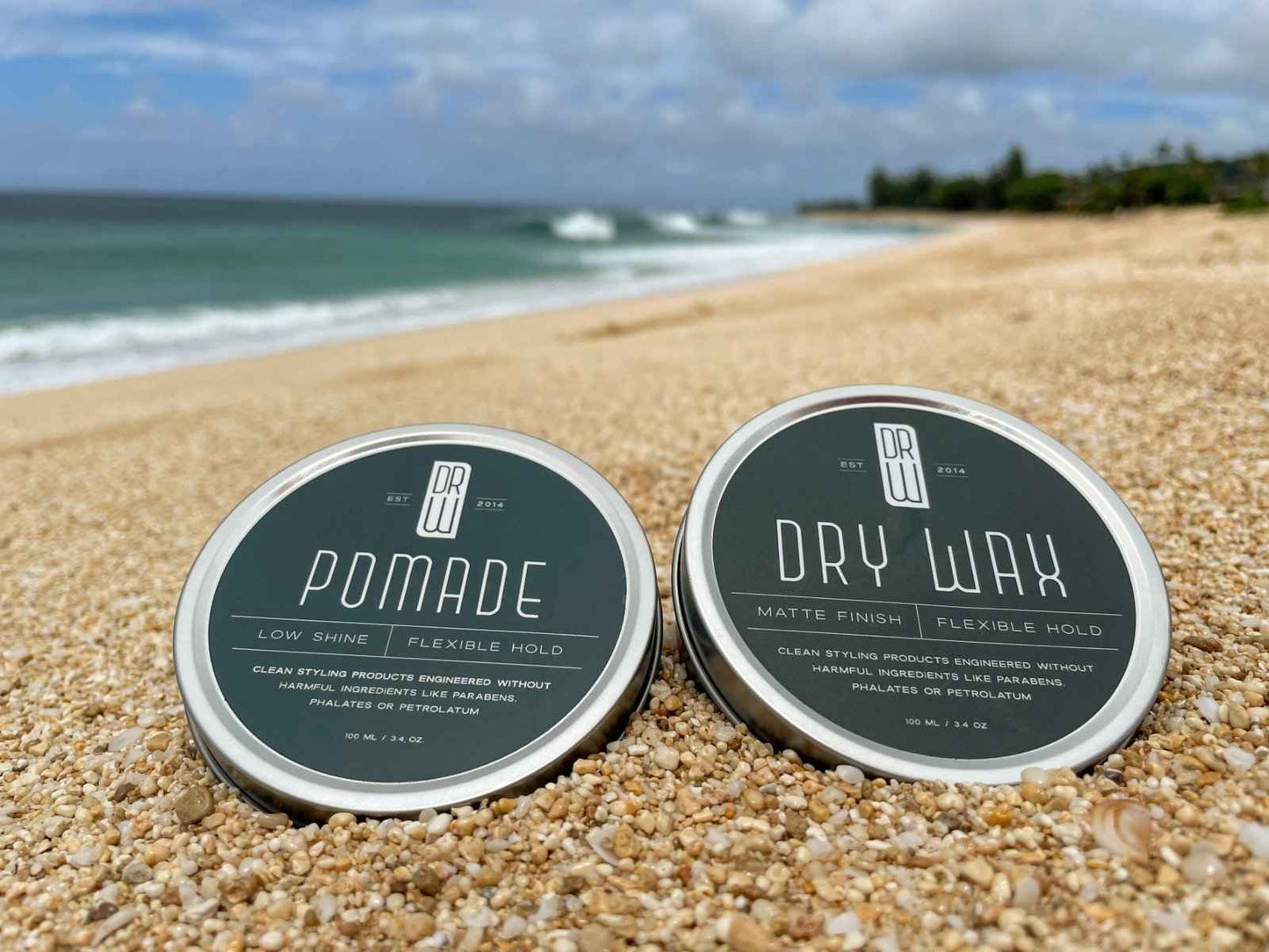 Two hair pomade tins with dark green tops and silver rims